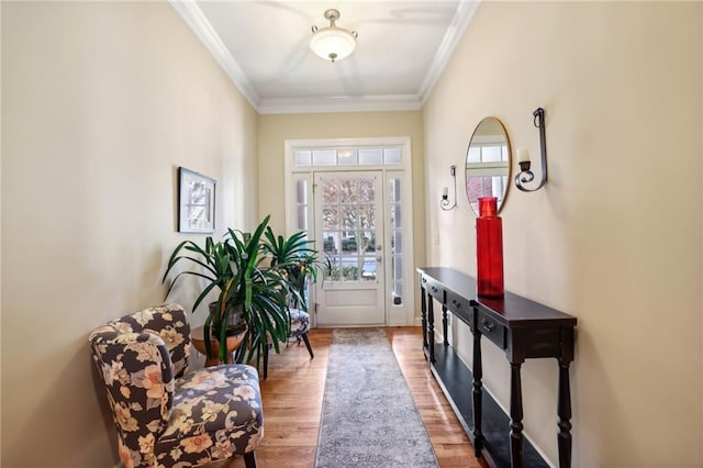 doorway with light hardwood / wood-style flooring and ornamental molding