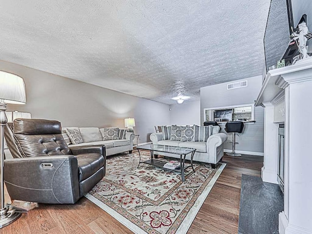 living room with a textured ceiling and dark wood-type flooring