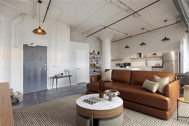 living room with a towering ceiling and concrete floors