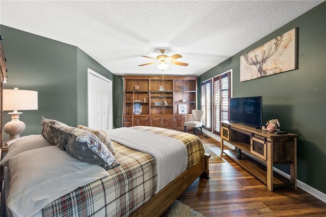 bedroom with ceiling fan, a textured ceiling, dark hardwood / wood-style flooring, and a closet