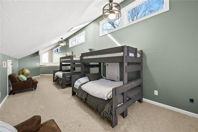 carpeted bedroom featuring a textured ceiling and lofted ceiling