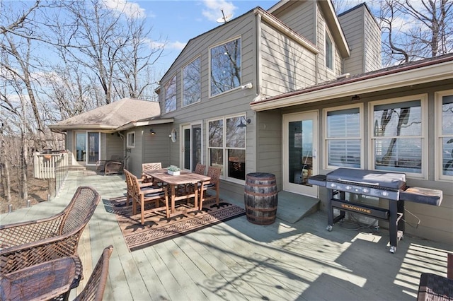 wooden deck with outdoor dining space and grilling area