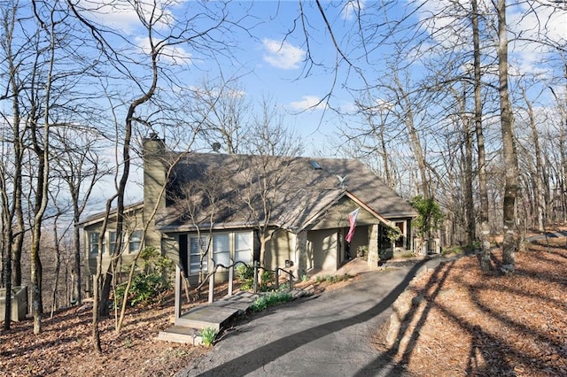 view of front of property featuring aphalt driveway and a chimney