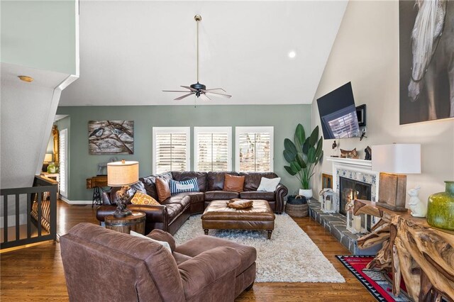 living room with ceiling fan, a fireplace, dark hardwood / wood-style flooring, and high vaulted ceiling