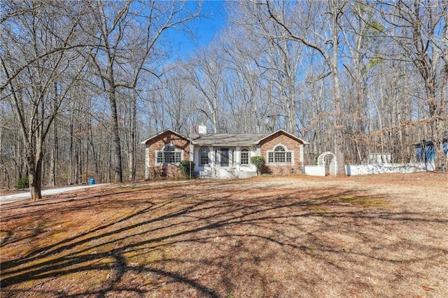 single story home featuring a forest view