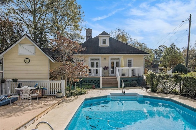 exterior space with a deck, a patio, fence, french doors, and a fenced in pool