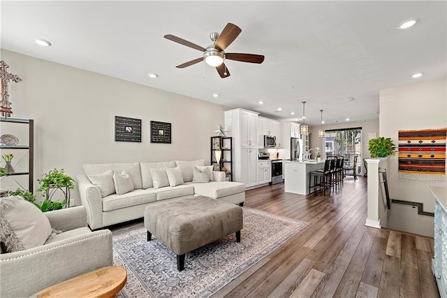 living room with ceiling fan, dark hardwood / wood-style floors, and sink