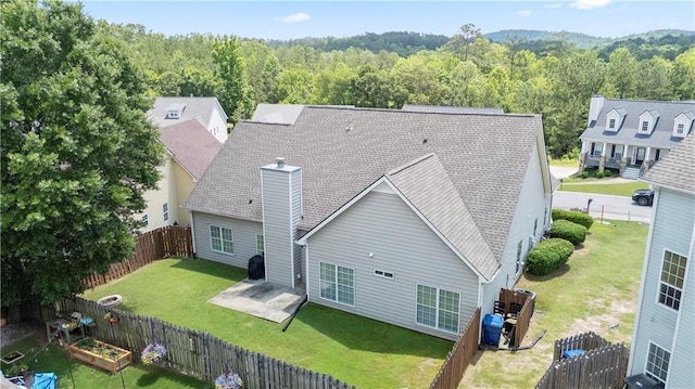 401 Oscar Way, Dallas, GA 30132 - back of house featuring a chimney, a wooded view, a patio, a fenced backyard, and a vegetable garden