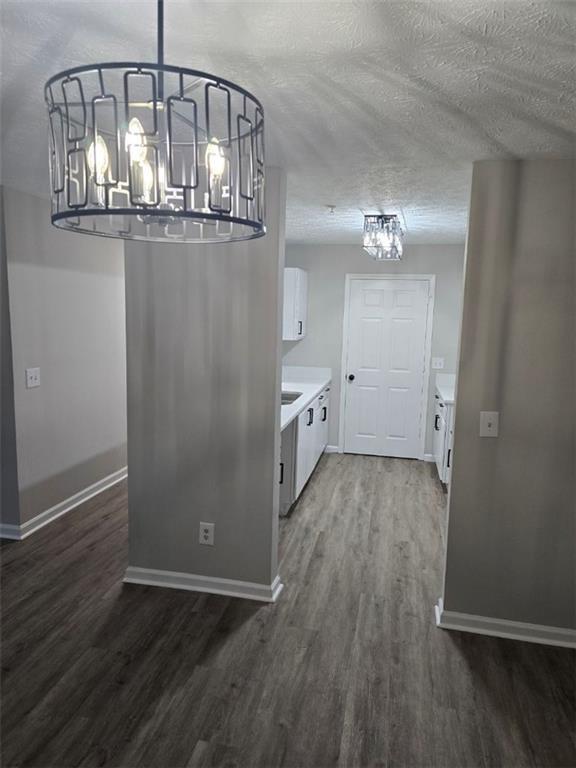 3201 Fairington Dr, Lithonia, GA 30038 - kitchen featuring a chandelier, wood finished floors, white cabinetry, baseboards, and a textured ceiling