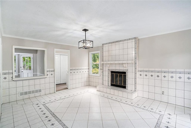 unfurnished living room with light tile patterned flooring, a healthy amount of sunlight, and a tile fireplace