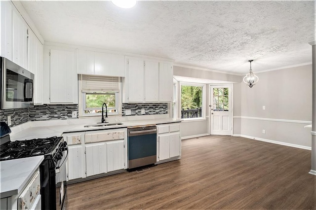 kitchen with white cabinets, appliances with stainless steel finishes, pendant lighting, and sink