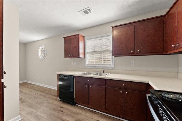 kitchen with light countertops, stainless steel range with electric cooktop, light wood-style floors, black microwave, and a sink