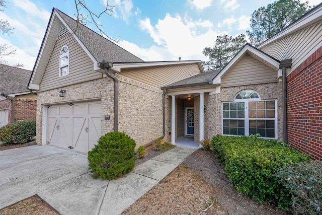 view of front facade featuring concrete driveway, brick siding, and a garage