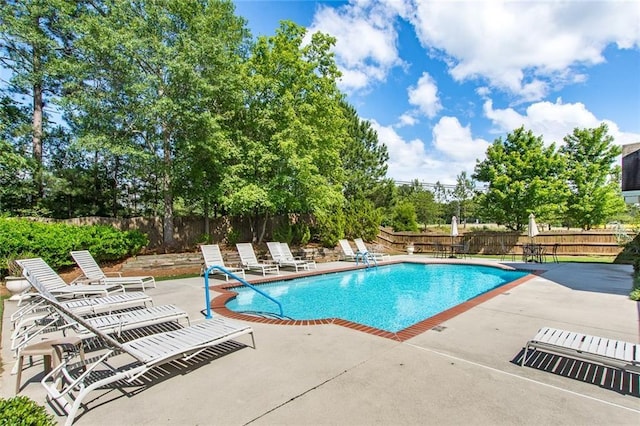 pool with a patio and fence