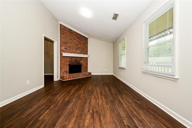 6194 Golden Meadow Ct, Riverdale, GA 30296 - unfurnished living room with dark wood-style flooring, lofted ceiling, and a brick fireplace