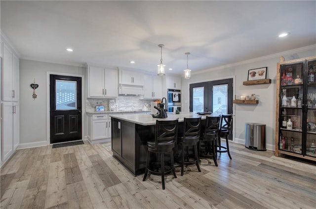 bar with crown molding, custom exhaust hood, baseboards, light wood-type flooring, and tasteful backsplash