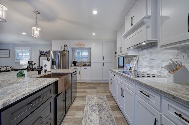 kitchen featuring light stone counters, backsplash, stainless steel appliances, and white cabinetry