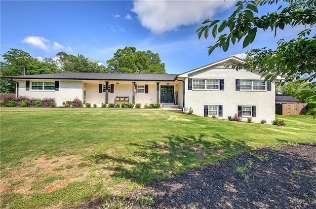 split level home with brick siding and a front yard