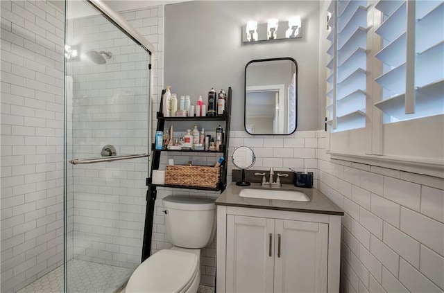 bathroom featuring vanity, tile walls, a stall shower, and toilet