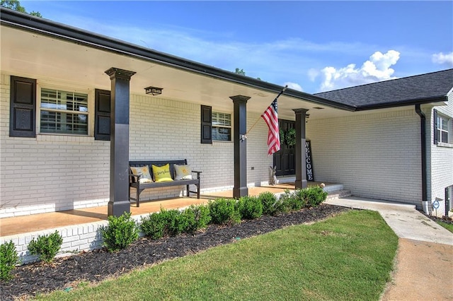 property entrance with covered porch and brick siding
