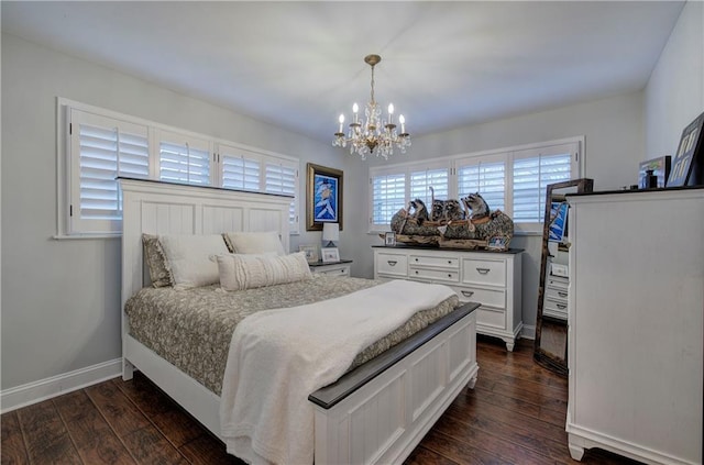 bedroom with a notable chandelier, dark wood finished floors, and baseboards