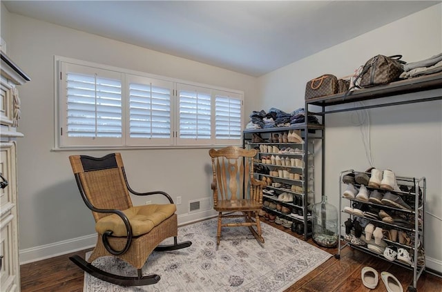 living area featuring baseboards, wood finished floors, and visible vents