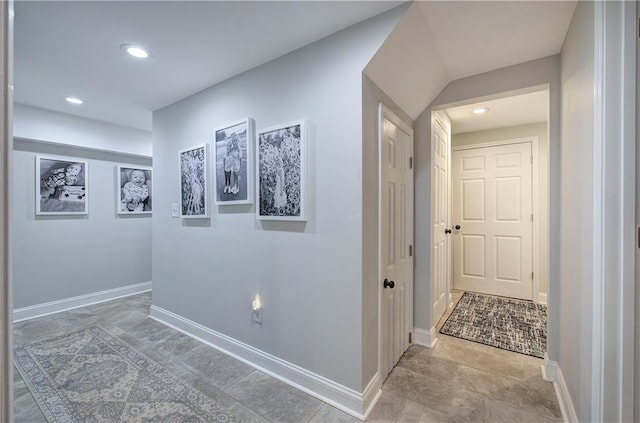 hall with baseboards, recessed lighting, and stone finish floor