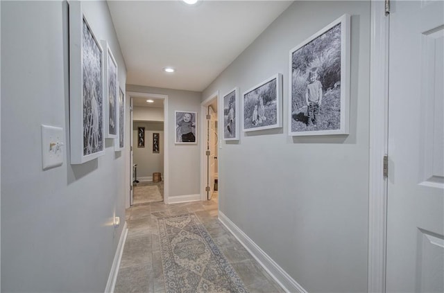 hall with recessed lighting and baseboards