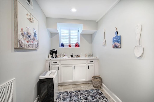 bathroom featuring vanity, baseboards, and visible vents