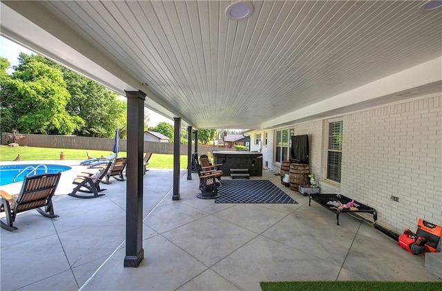 view of patio / terrace with a hot tub, a fenced in pool, and a fenced backyard