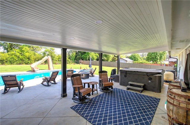 view of patio / terrace featuring a fenced backyard, a fenced in pool, and a hot tub