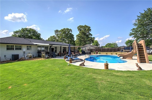 view of swimming pool featuring a patio, a fenced backyard, central AC unit, a lawn, and a water slide