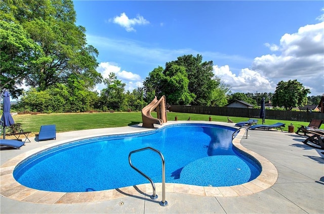 view of pool with a yard, a water slide, and a fenced backyard