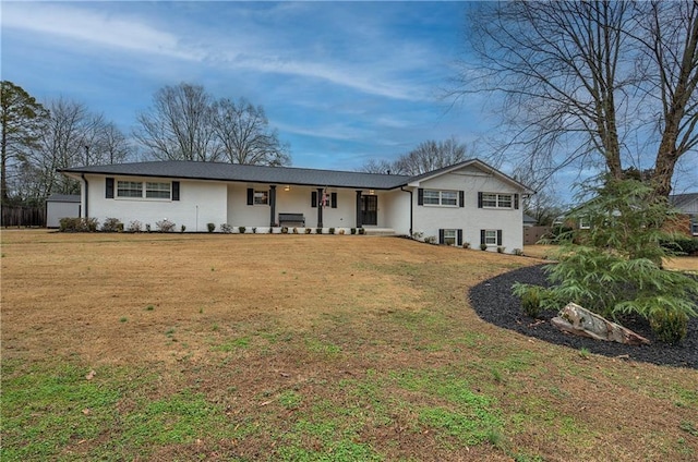 single story home with covered porch and a front yard