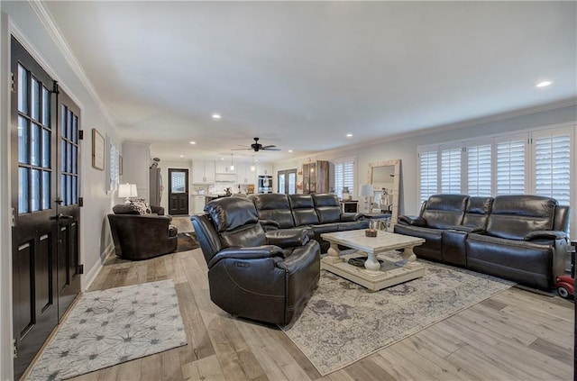 living area featuring crown molding, recessed lighting, and light wood-style floors