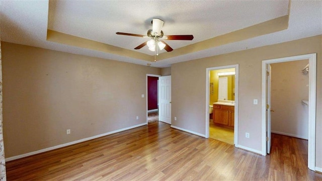 210 Overview Ct, Villa Rica, GA 30180 - unfurnished bedroom with a raised ceiling, a walk in closet, light wood-type flooring, and baseboards