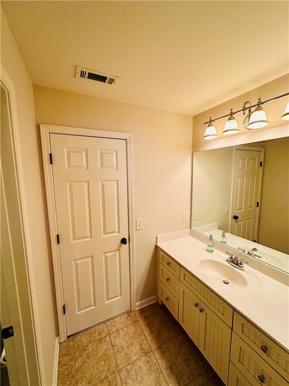 bathroom featuring vanity, baseboards, visible vents, and tile patterned flooring