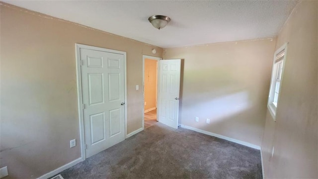 unfurnished bedroom featuring dark colored carpet