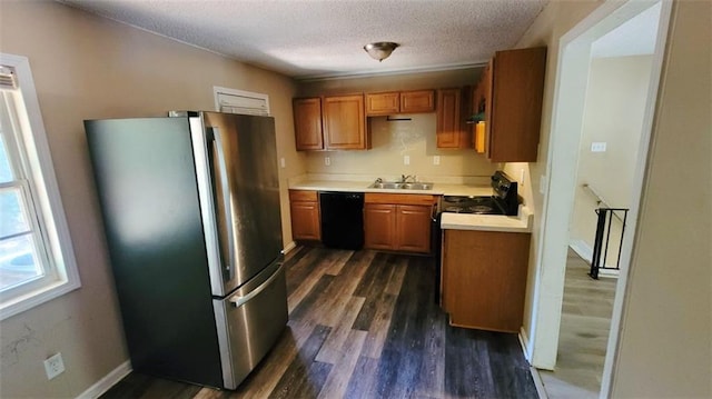 kitchen featuring dark hardwood / wood-style flooring, sink, a textured ceiling, and black appliances