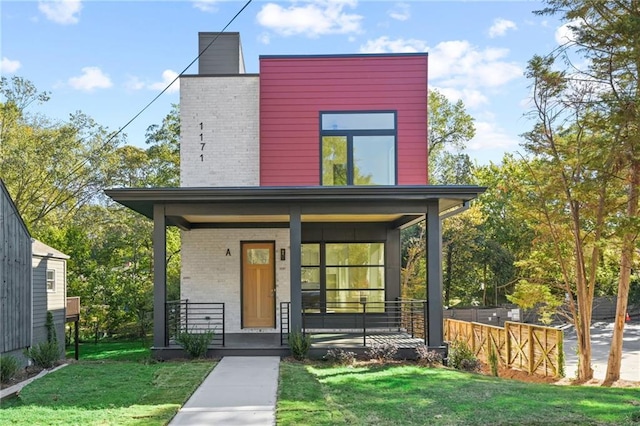 view of front of house with covered porch and a front lawn