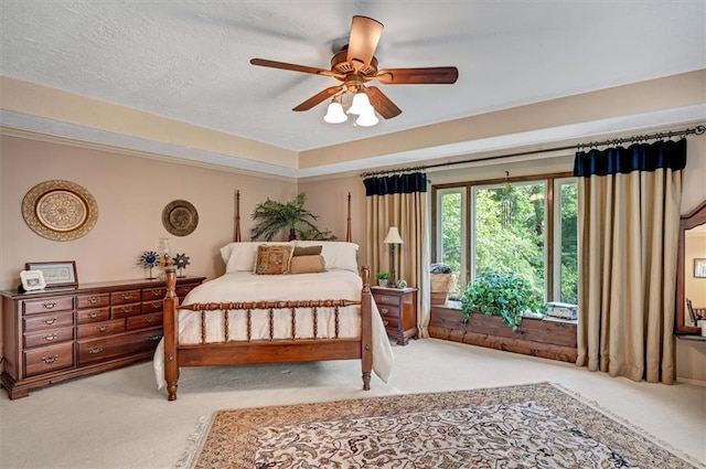 carpeted bedroom featuring a textured ceiling and ceiling fan