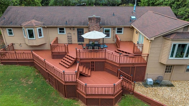 back of property featuring a yard and a deck