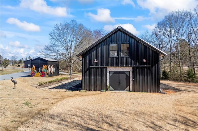 view of outbuilding featuring dirt driveway and an outdoor structure