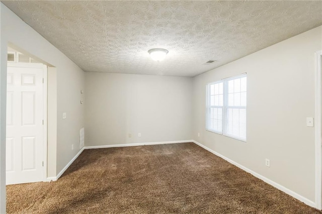 unfurnished room with dark carpet and a textured ceiling