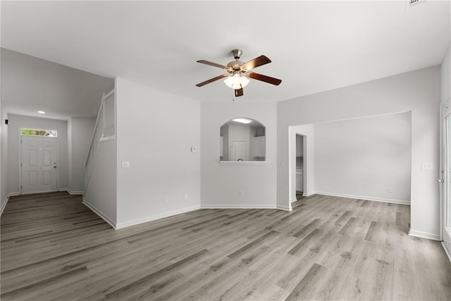 124 Oakmont Dr, Dawsonville, GA 30534 - unfurnished living room with ceiling fan, light wood-style flooring, baseboards, and arched walkways