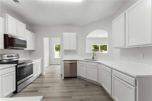124 Oakmont Dr, Dawsonville, GA 30534 - kitchen with stainless steel appliances, a sink, arched walkways, and white cabinets