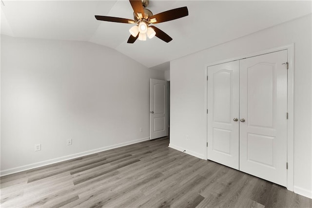 124 Oakmont Dr, Dawsonville, GA 30534 - unfurnished bedroom featuring wood finished floors, lofted ceiling, a closet, baseboards, and a ceiling fan