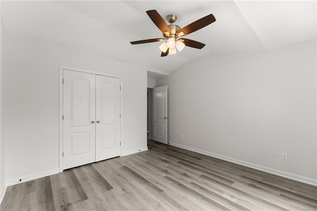 124 Oakmont Dr, Dawsonville, GA 30534 - unfurnished bedroom with vaulted ceiling, wood finished floors, a closet, and baseboards