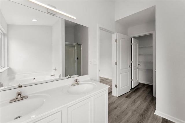 124 Oakmont Dr, Dawsonville, GA 30534 - bathroom featuring a stall shower, wood finished floors, a garden tub, a walk in closet, and double vanity