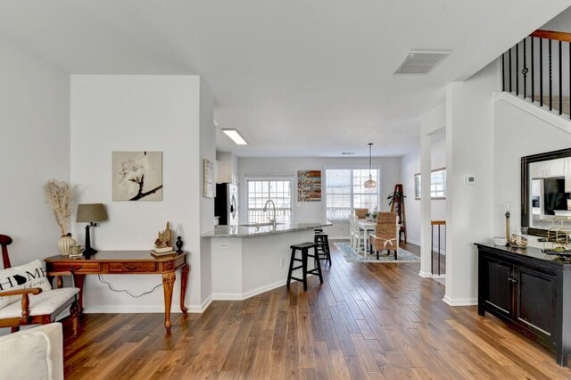 living room with ceiling fan, a healthy amount of sunlight, wood-type flooring, and a fireplace